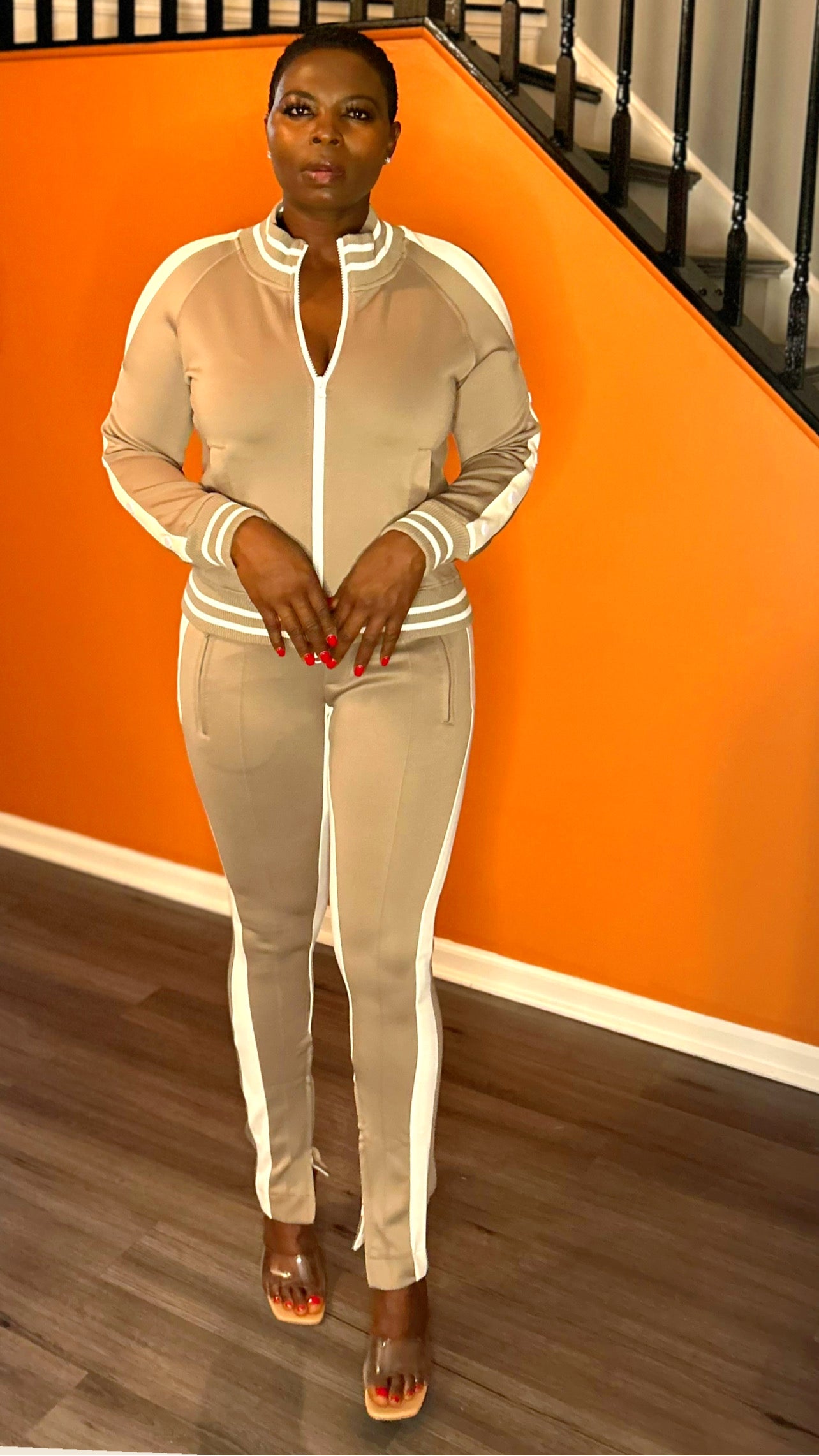 Model wearing a natural tracksuit with a trendy cold-shoulder top and matching shoes.