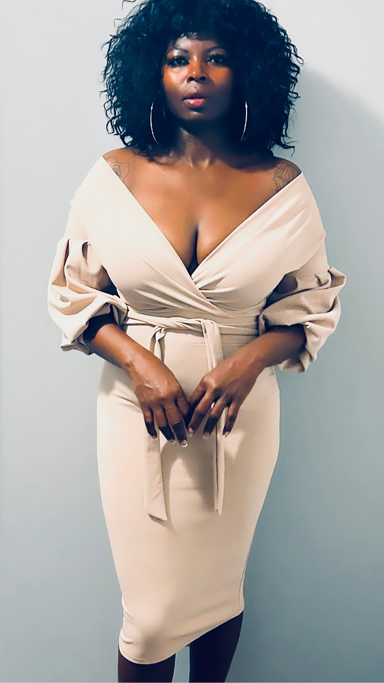 Front profile of the nude midi dress showcasing its body-hugging fit and belted waist."
