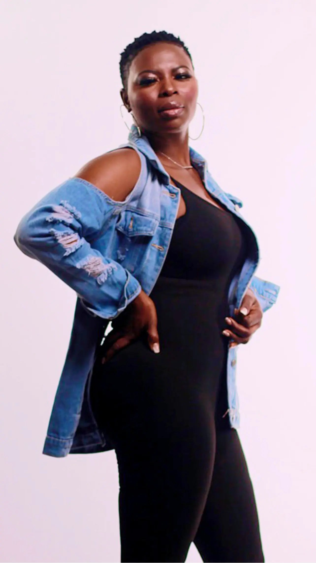 Side profile of the cold shoulder denim jacket showcasing the distressed design.