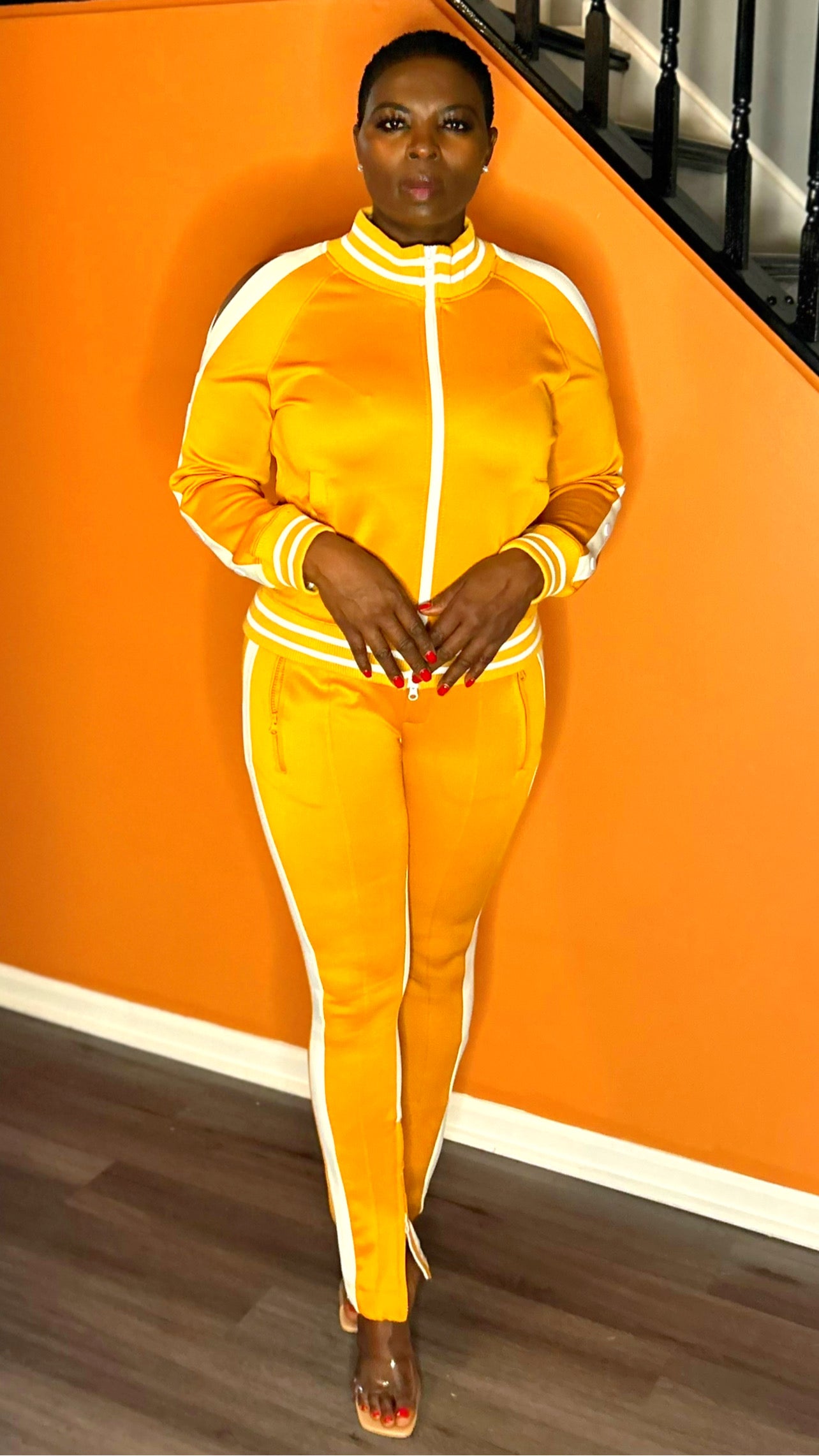 Model wearing a mustard tracksuit with a cold-shoulder top