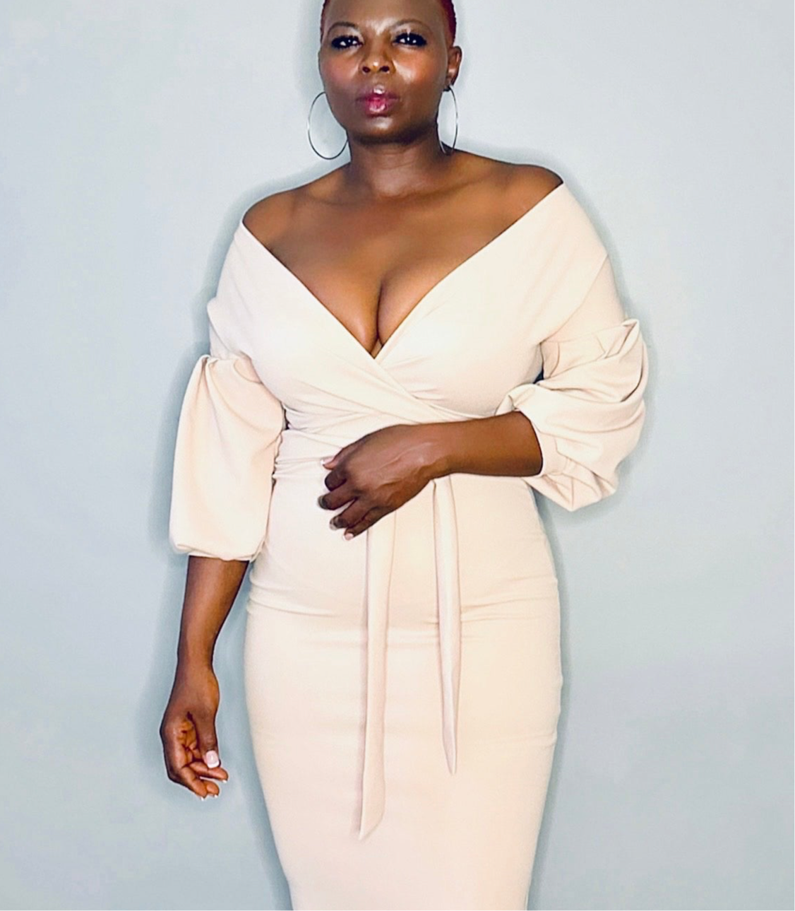 Off-the-shoulder nude bodycon midi dress paired with simple accessories for a chic vibe.