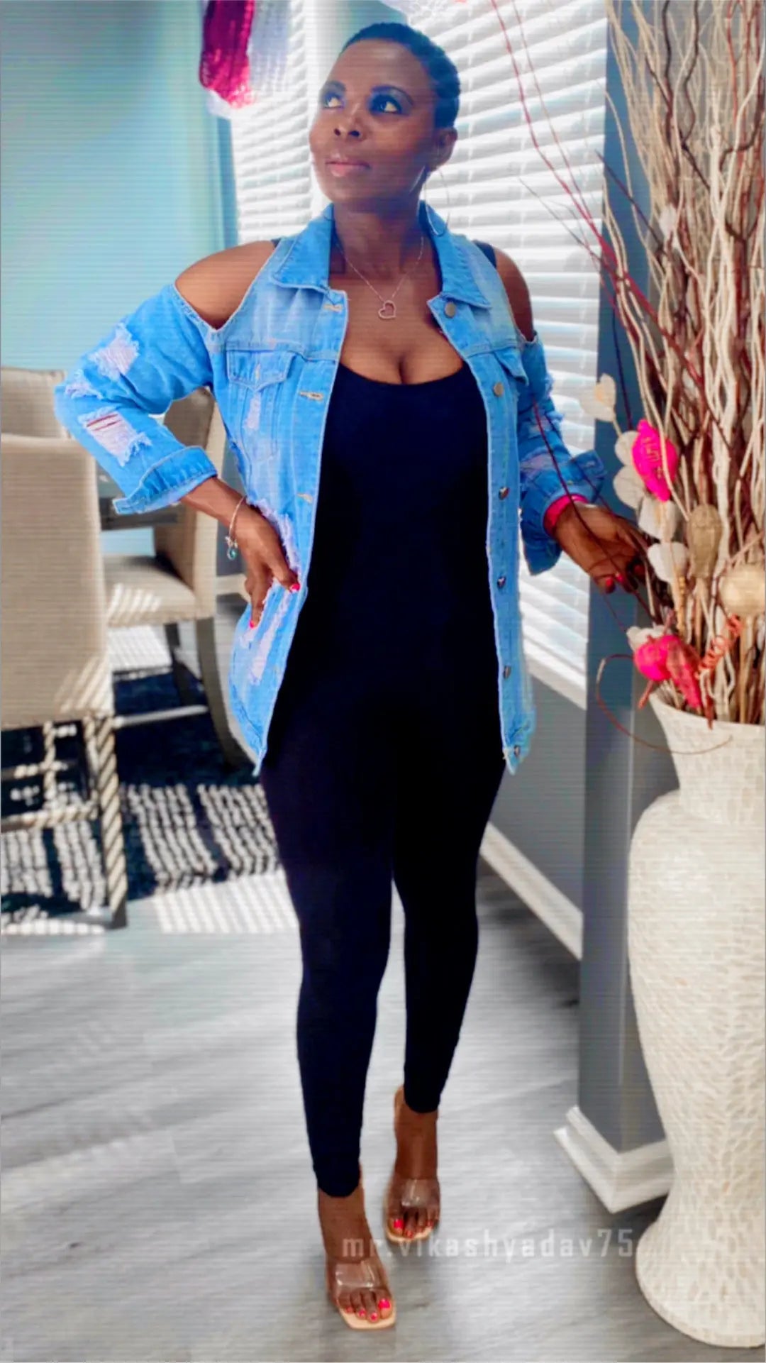 Model wearing a long sleeve denim jacket with ripped details and cold shoulder cutouts