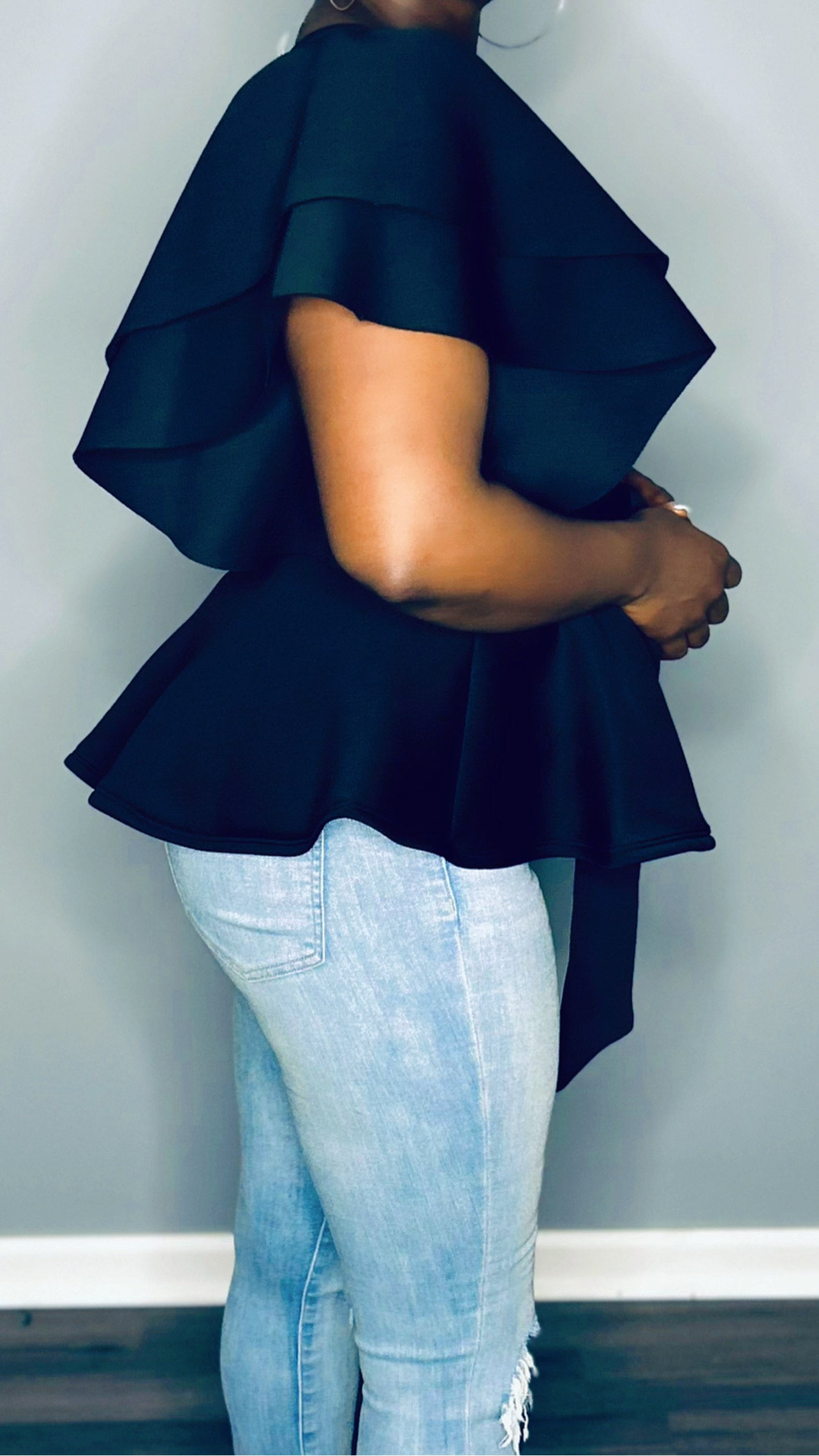 Side profile of the black top, showcasing the deep v-neck and flowy fit