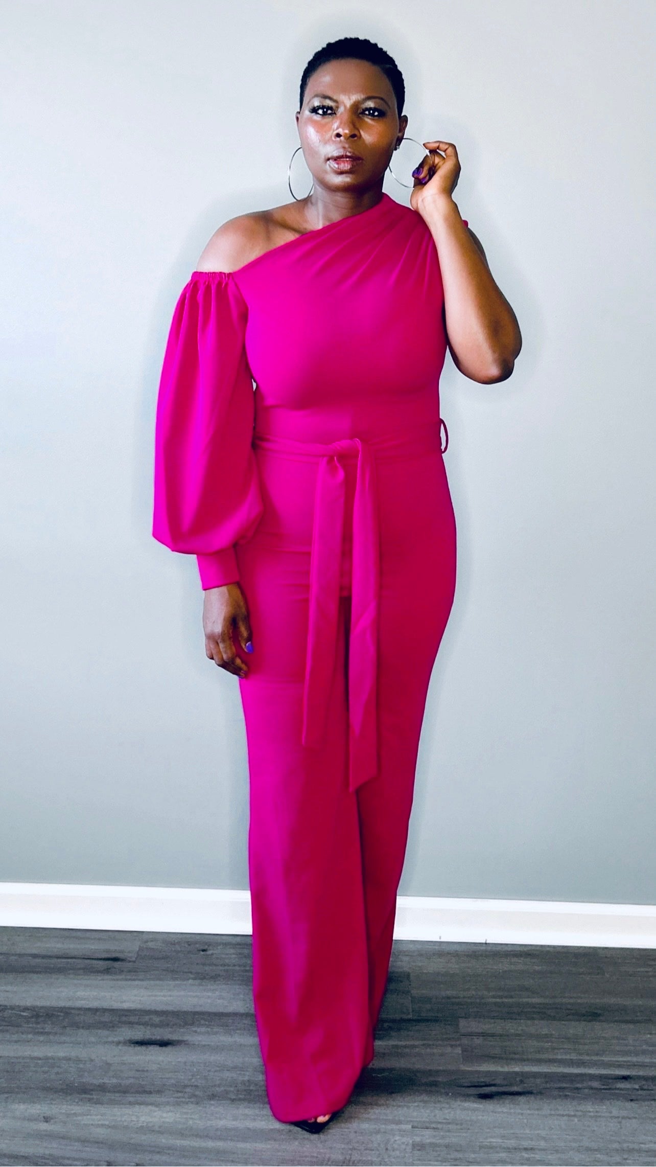 Full-length view of the magenta jumpsuit styled with heels for a glamorous look.