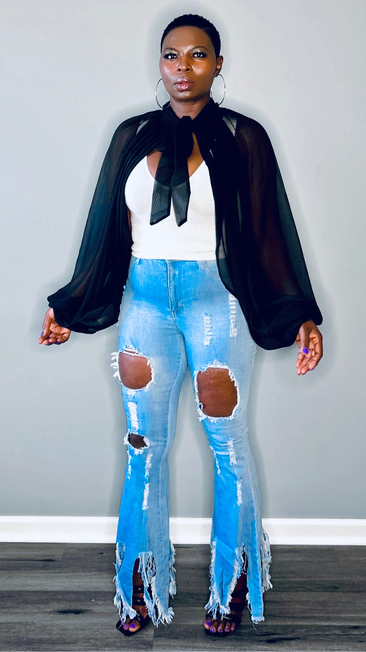 full-length shot of the black organza blouse styled with high heels.